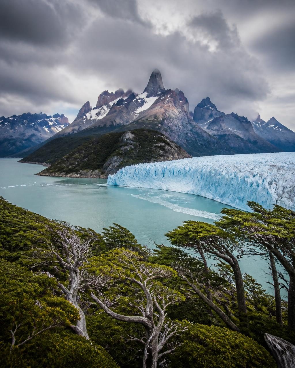 Glacier reaching a milky blue channel below granite spires in Patagonia