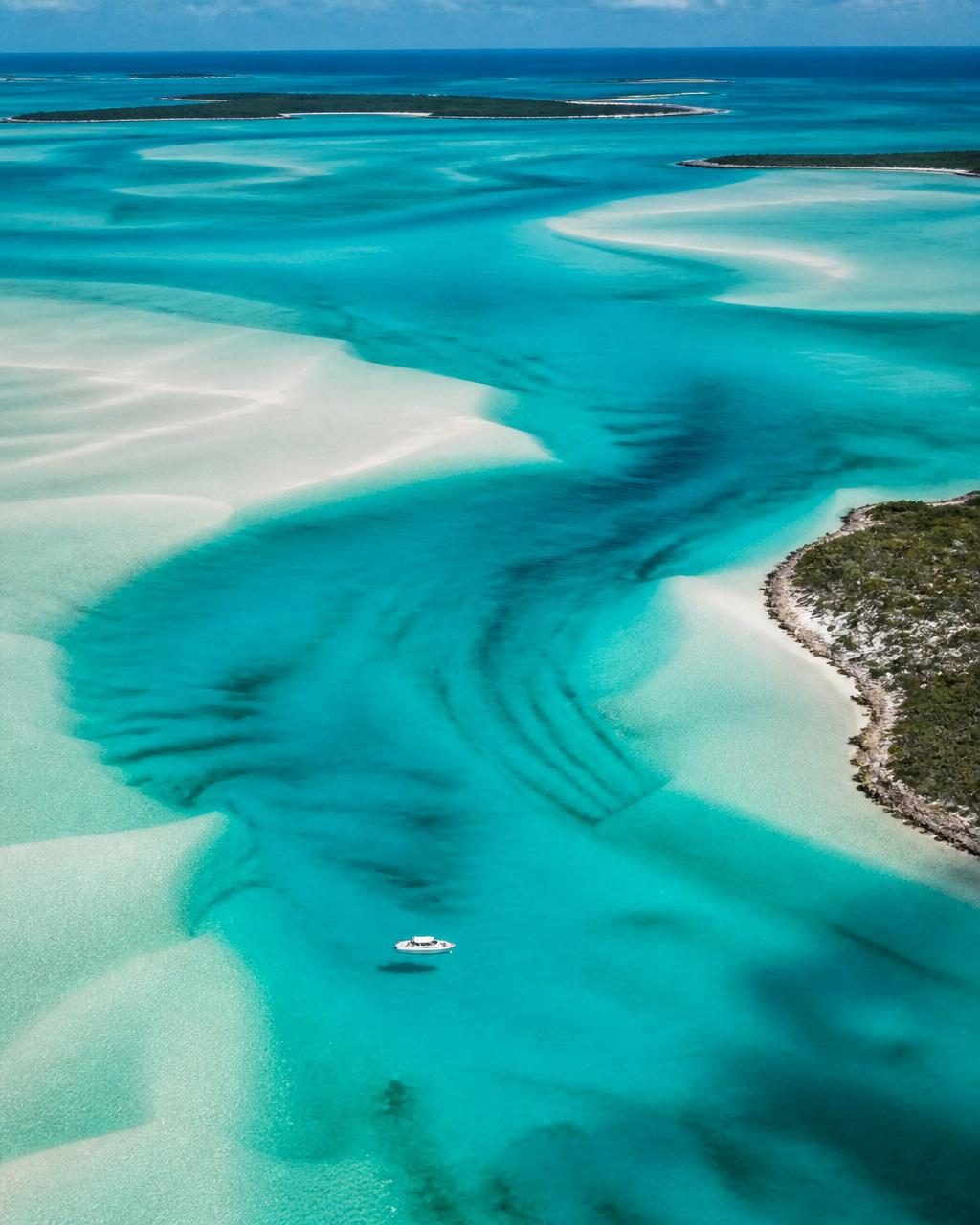 Aerial view of pale sandbanks and turquoise channels in the Exumas